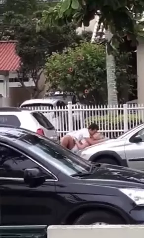 Flagra quente de um casal se amarrando no capô do carro no meio do centro da cidade