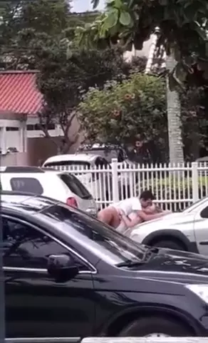 Flagra quente de um casal se amarrando no capô do carro no meio do centro da cidade